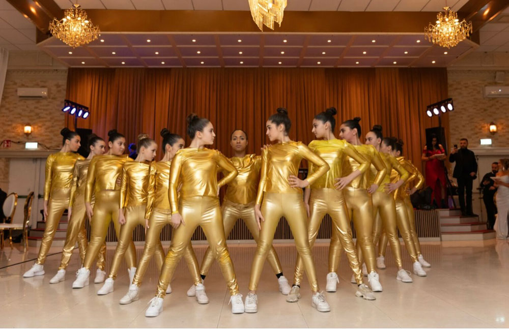 Dansare har guldiga dräkter på sig